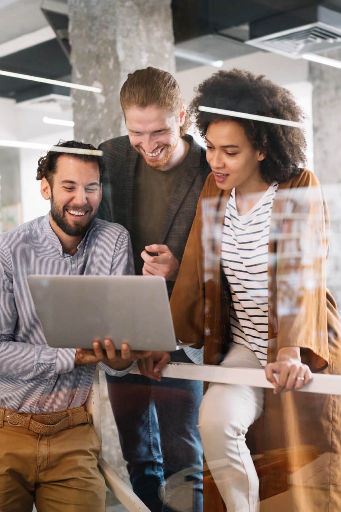 a group of people looking at a laptop