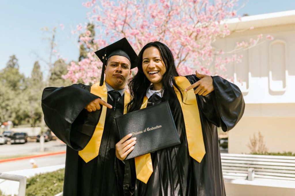 a man and woman in graduation gowns and caps