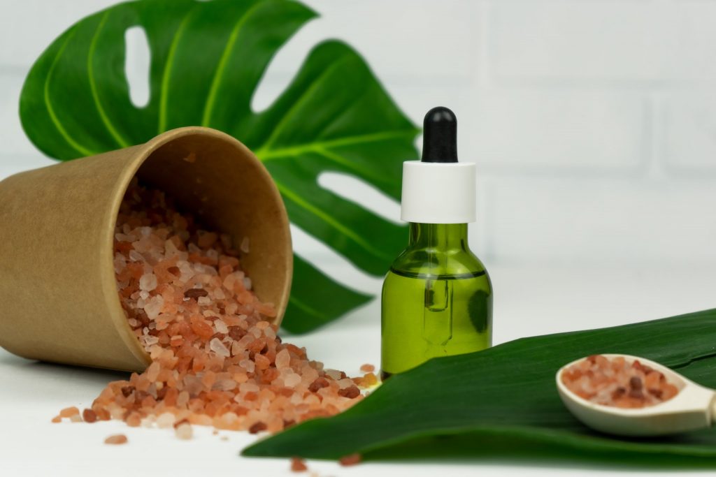 a bottle of oil next to a plant